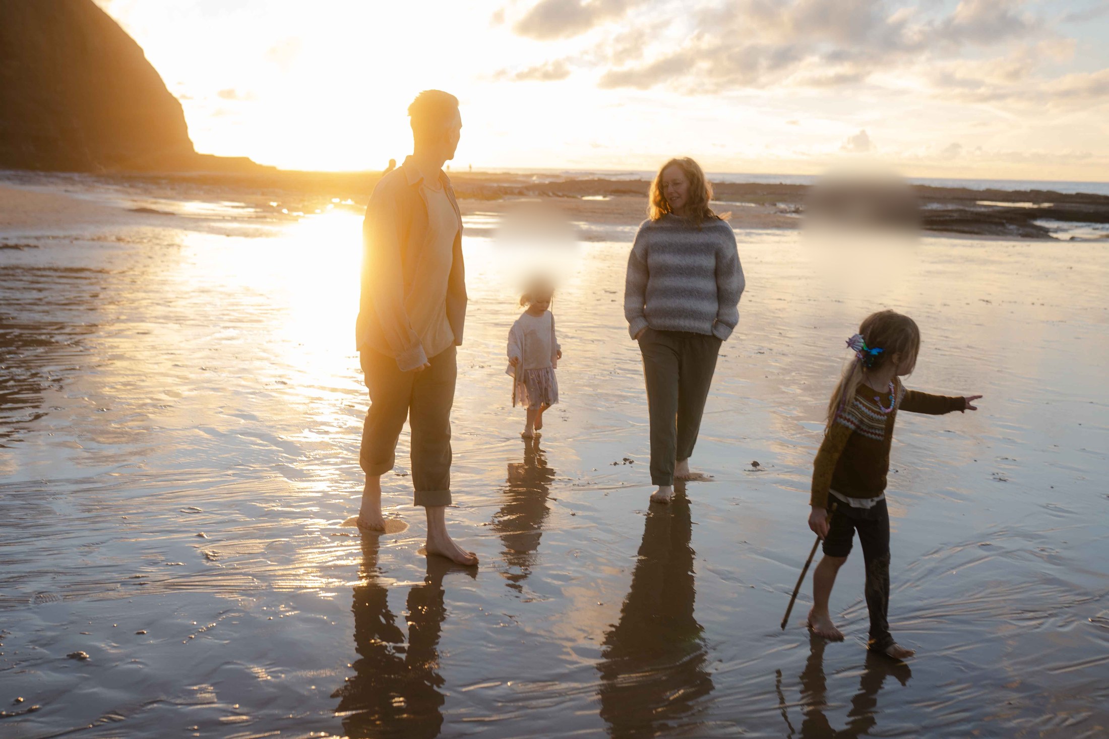 Familie am Strand bei Sonnenuntergang